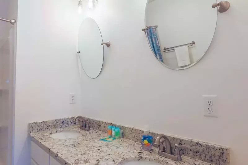 The upstairs bathroom has a large, double sink vanity with granite counters.