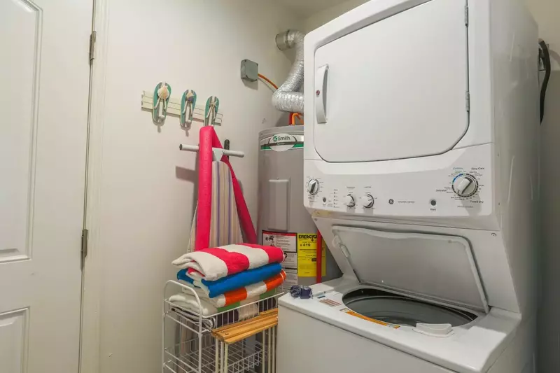 There is a stacked washing machine & dryer near the back door.