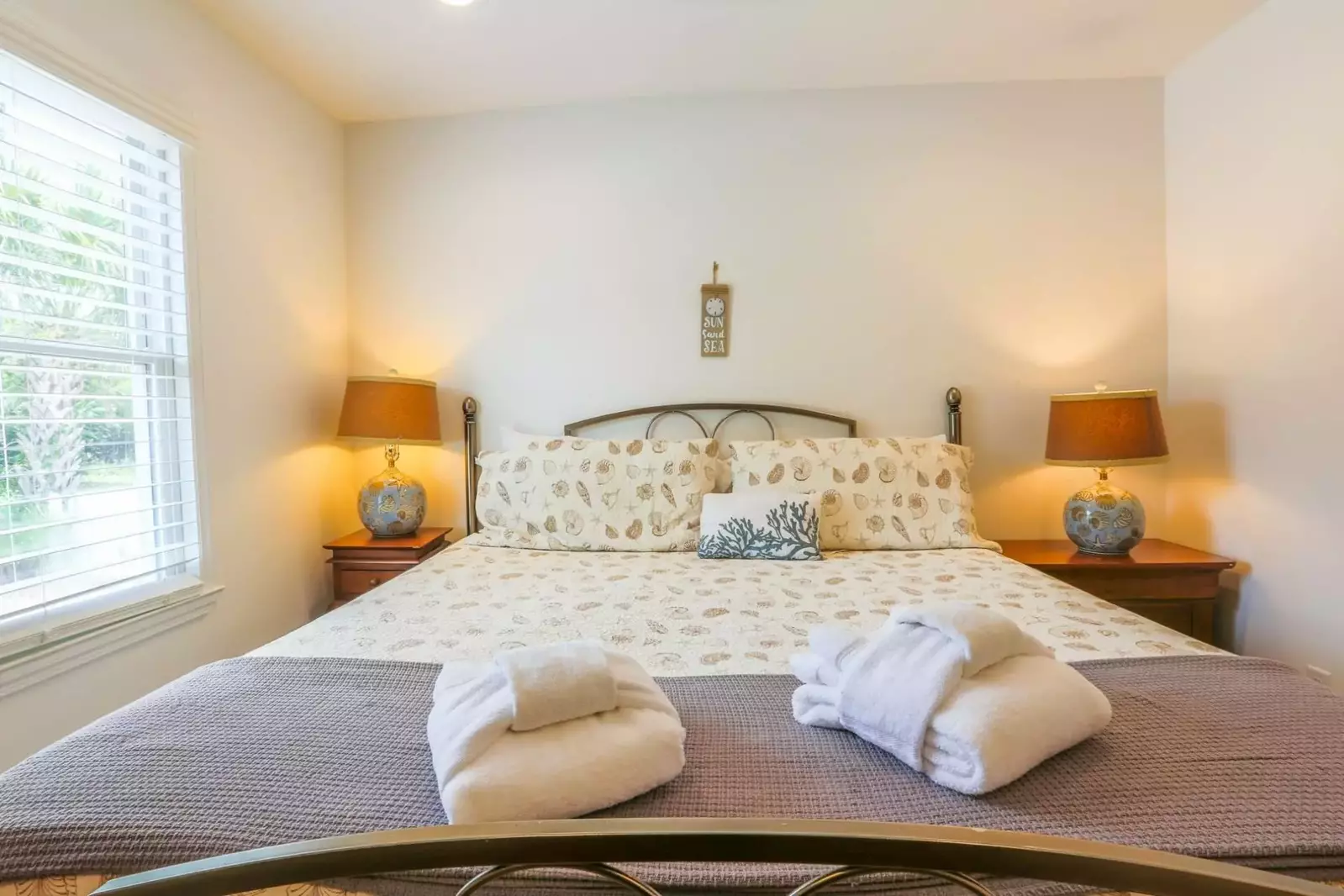 The master bedroom has a king bed and nightstands with reading lamps.