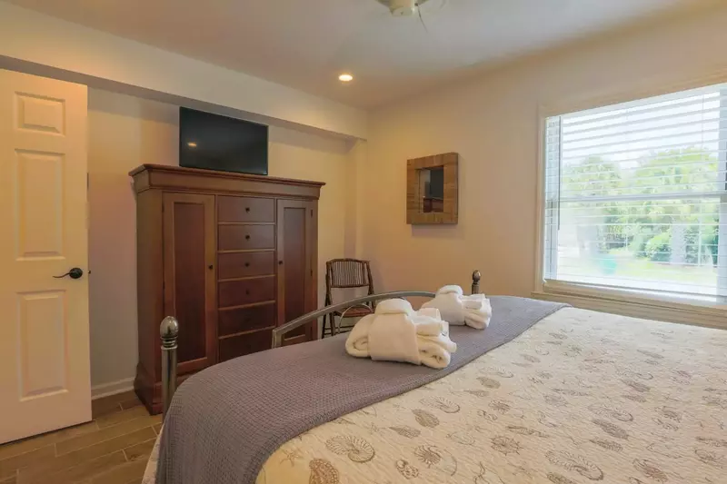 The master bedroom also has a dresser, smart TV and ceiling fan.