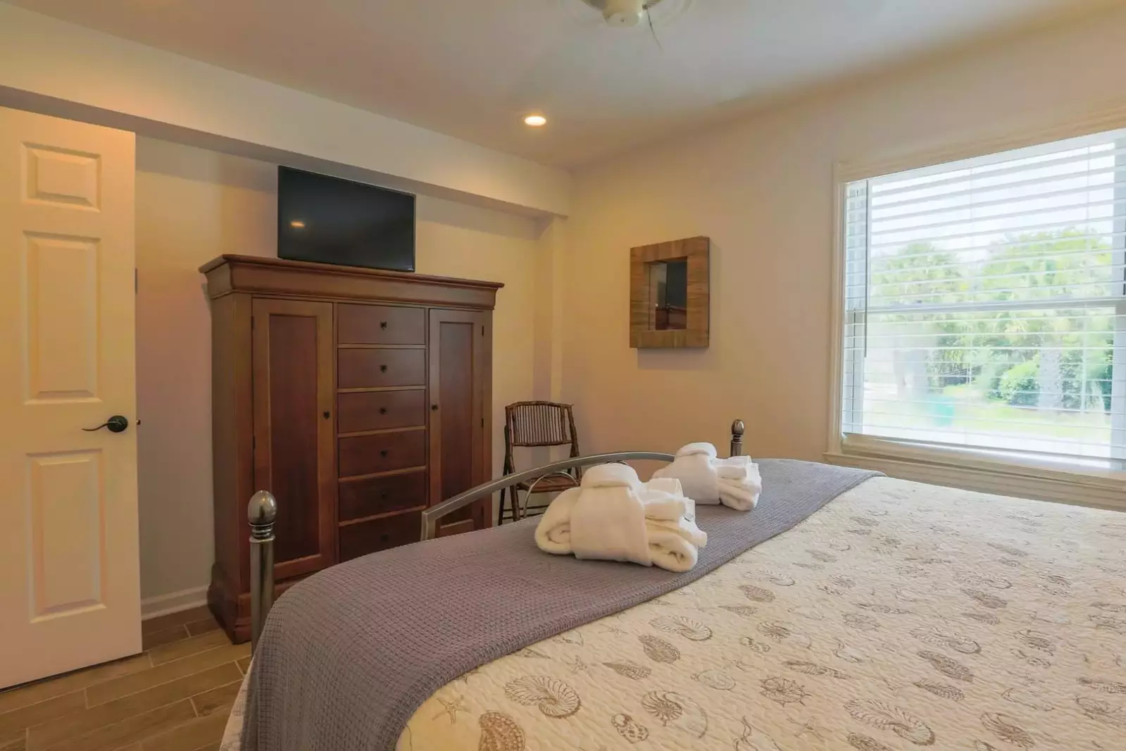 The master bedroom also has a dresser, smart TV and ceiling fan.