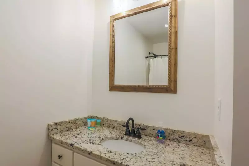 The first floor bathroom features a spacious vanity with granite counters.