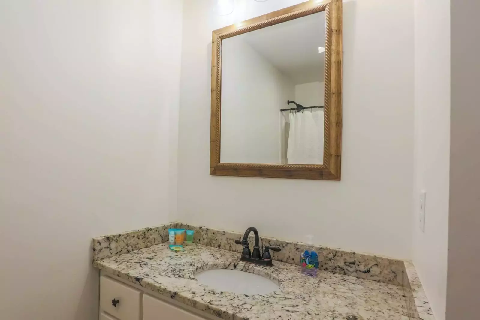 The first floor bathroom features a spacious vanity with granite counters.