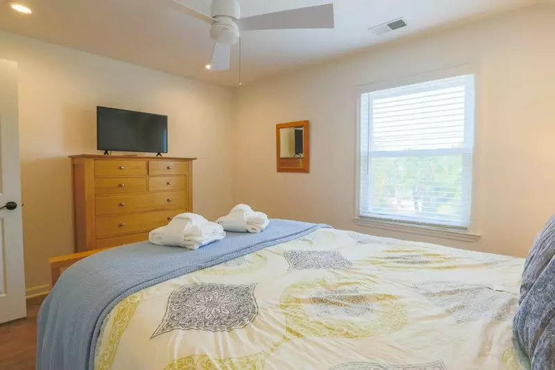 This second floor bedroom has a dresser and smart TV.