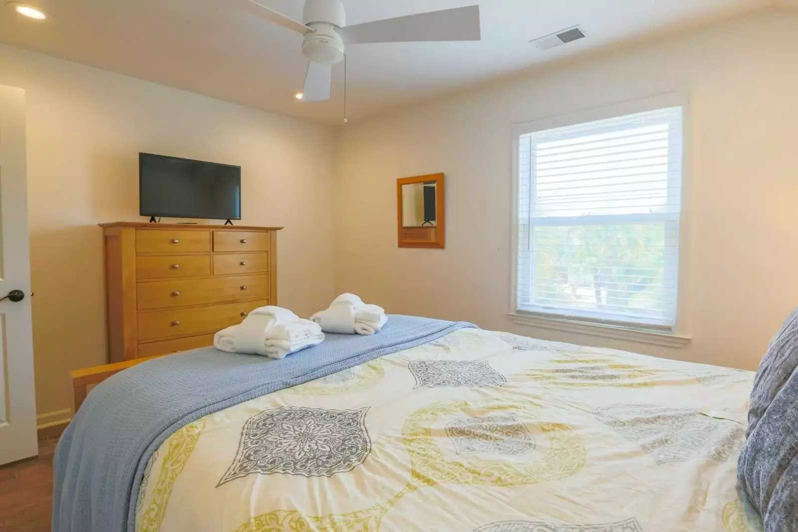 This second floor bedroom has a dresser and smart TV.
