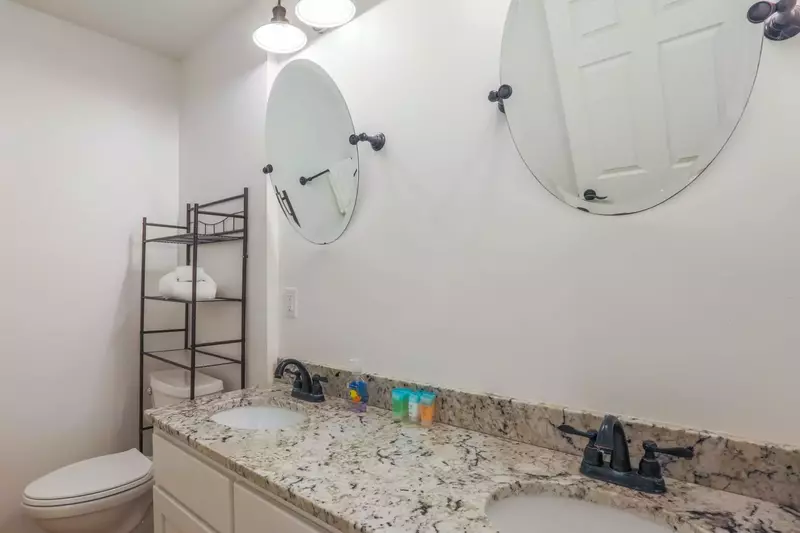 This spacious bathroom with a double sink vanity and walk-in shower is located on the second floor.