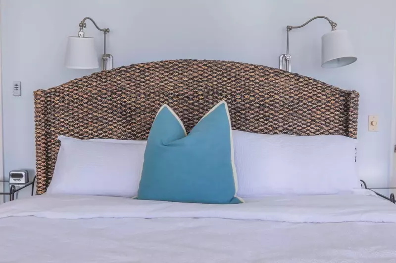 The master bedroom features a king bed with night stands & wall sconces.