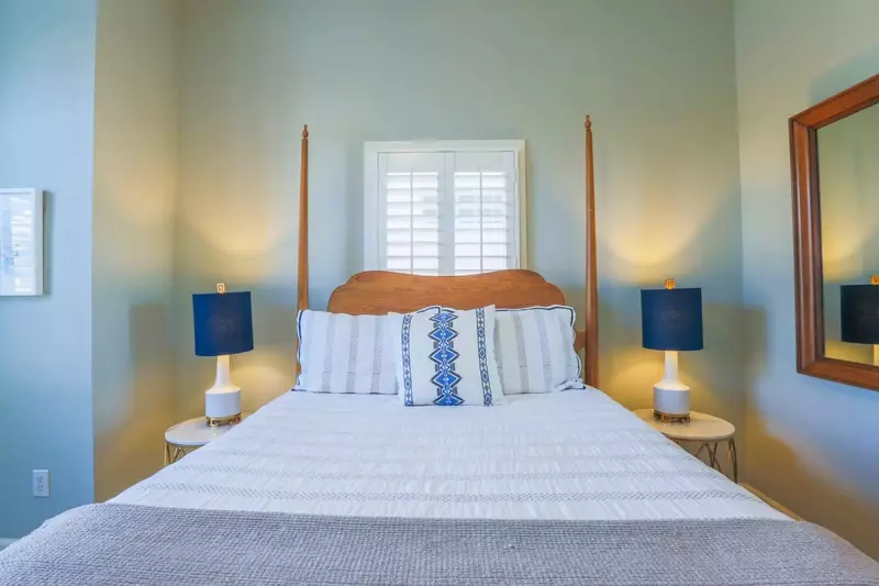 This guest bedroom has a queen bed and night stands with reading lamps.