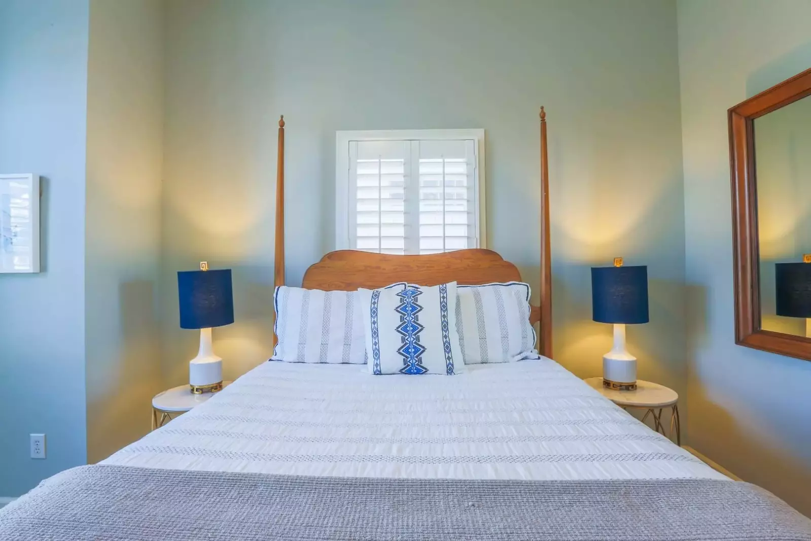 This guest bedroom has a queen bed and night stands with reading lamps.
