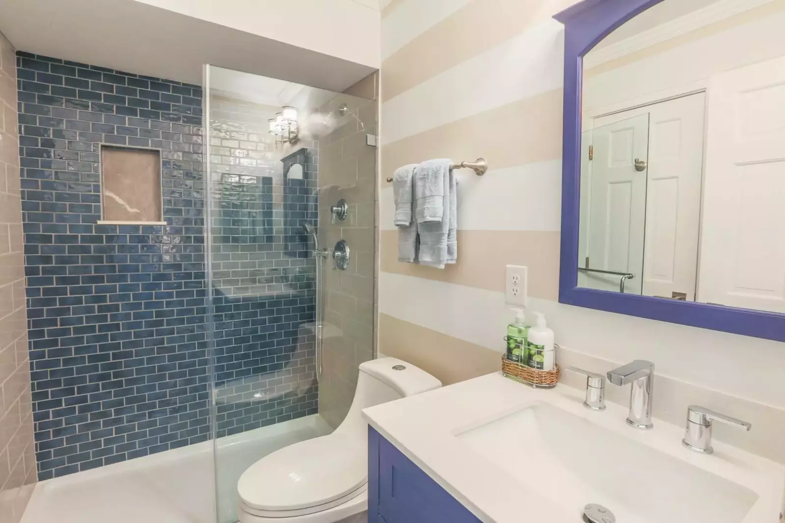The renovated bathroom features a beautifully tiled, walk-in shower and a new vanity.