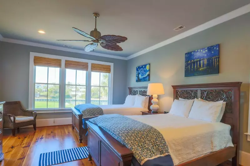 The fourth bedroom features two queen beds and wonderful views of the lake behind the house.