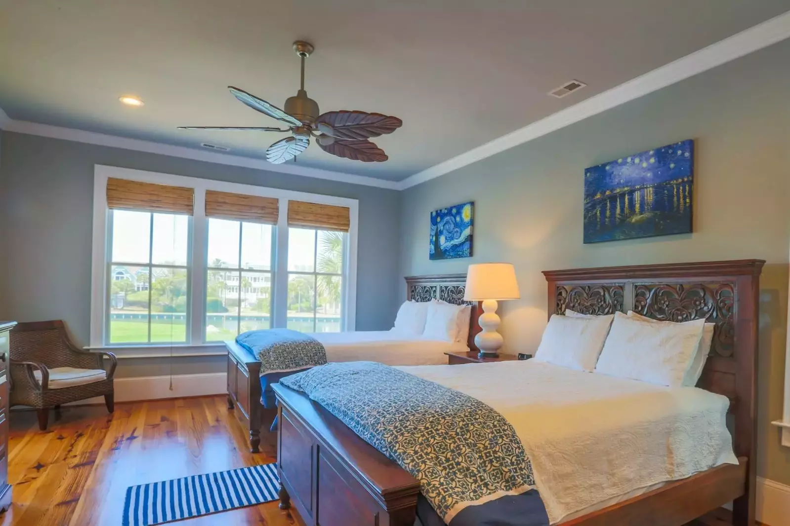 The fourth bedroom features two queen beds and wonderful views of the lake behind the house.