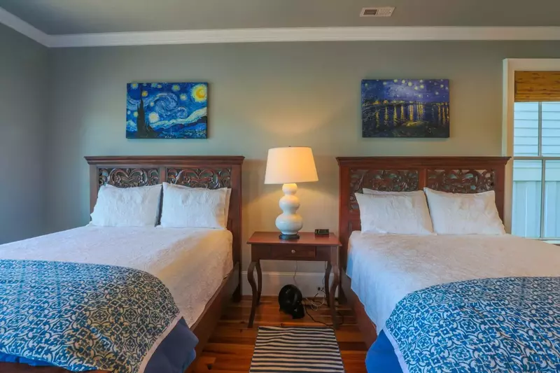 There is a nightstand with reading lamp separating the two queen beds.