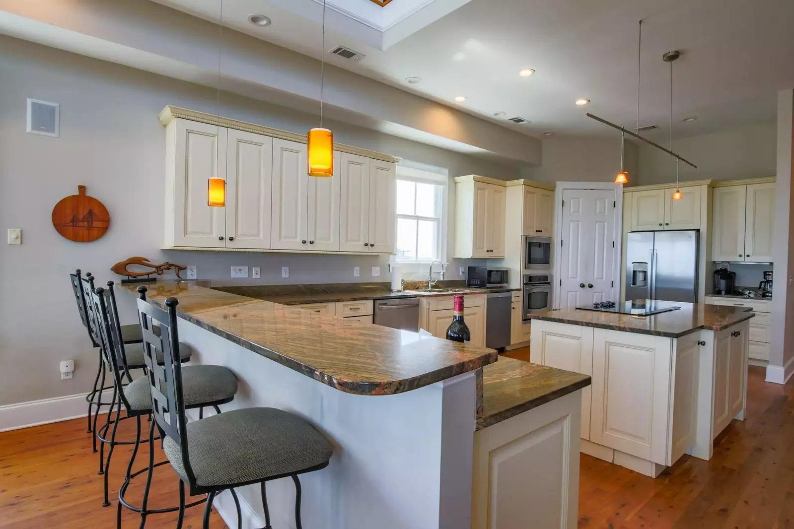 There are four kitchen stools situated alongside the kitchen counter.
