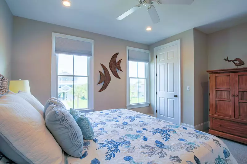 This room features a king bed, armoire with smart TV and views out of the front side of the home.