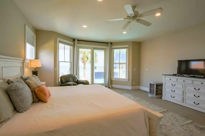 This guest bedroom also features a dresser, a smart TV and ceiling fan.