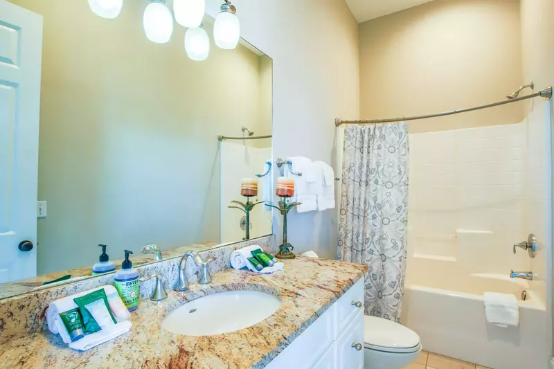 This bathroom features a spacious vanity and a shower/tub combo.