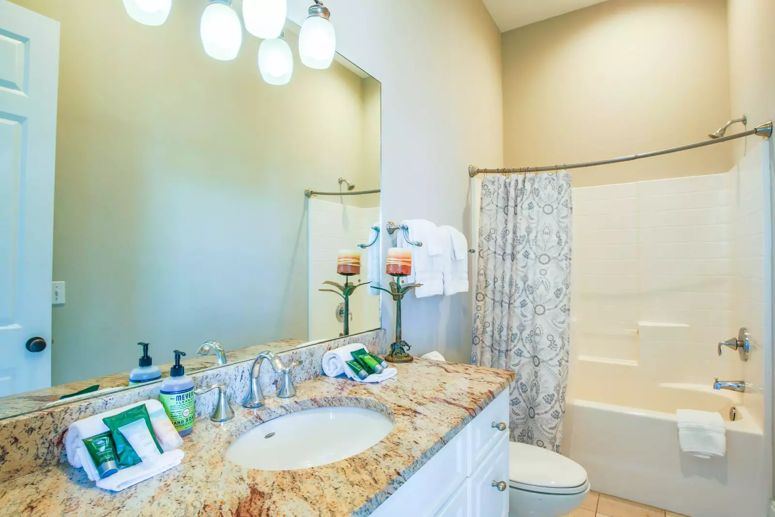 This bathroom features a spacious vanity and a shower/tub combo.
