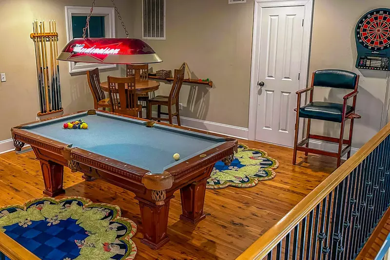 The third floor of the home features a game room with a pool table, dart board and card table.
