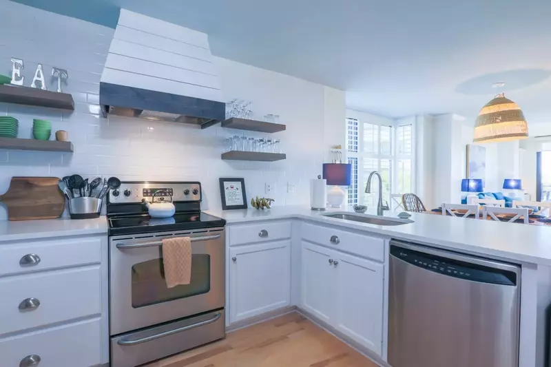 The newly renovated kitchen features stainless steel appliances and a white backsplash tile.