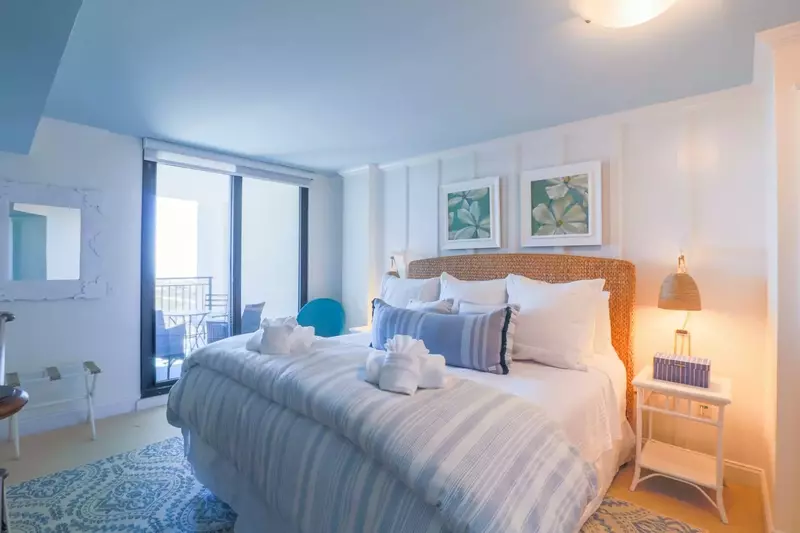 The master bedroom suite features a king bed and night stands with reading lamps.