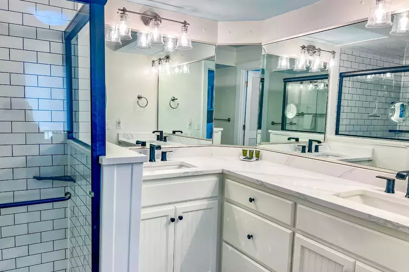 The renovated en suite bathroom has a double sink vanity and tiled, walk-in shower.