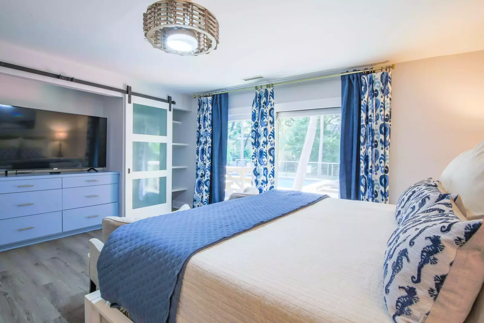 This master suite has a large screen smart TV, dresser and two closets.