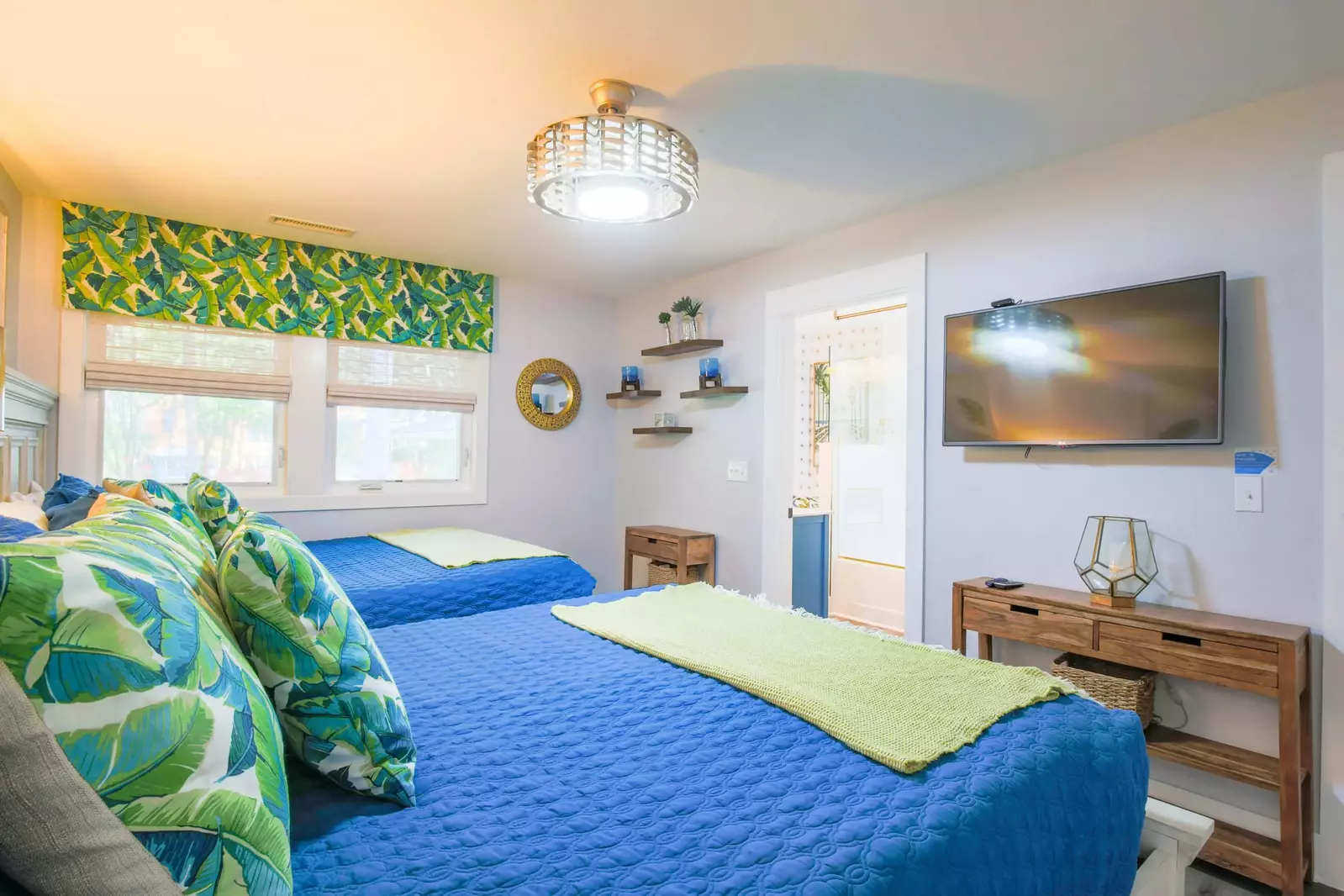This guest bedroom has a mounted streaming TV and an en suite bathroom.
