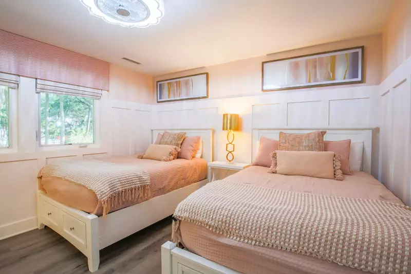 This guest bedroom has two full beds and a night stand with a reading lamp.