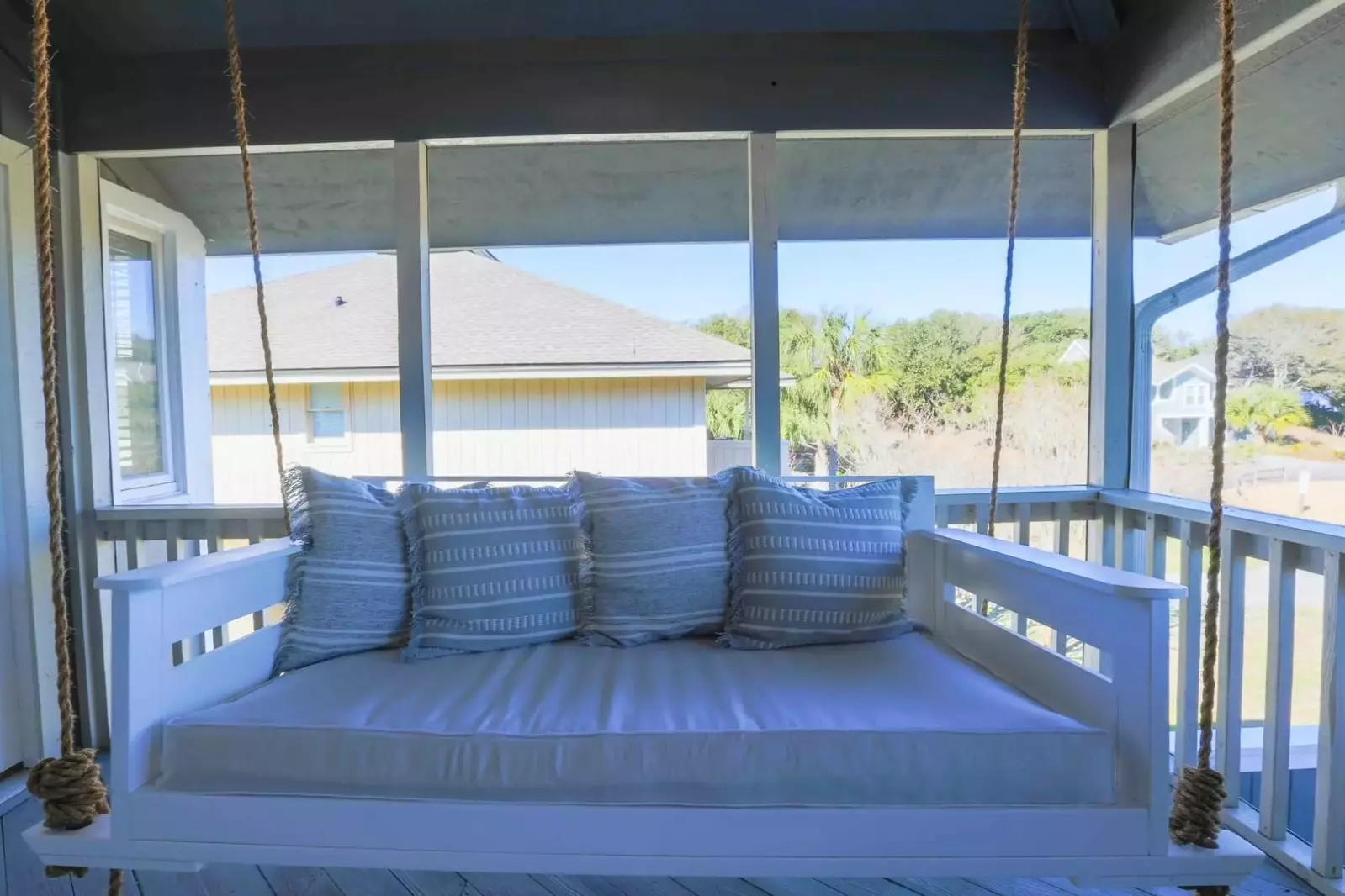 You'll enter this screened porch -- with a fabulous swing bed -- to find the home's front door.