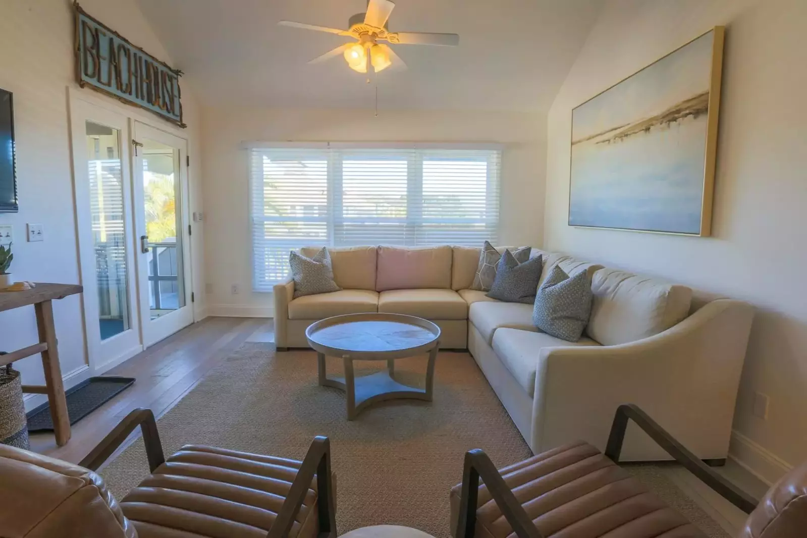 The living room has vaulted ceilings, carefully selected funishings and a mounted large screen TV.