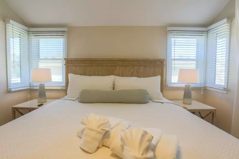 The master bedroom suite features a king bed and night stands with reading lamps.