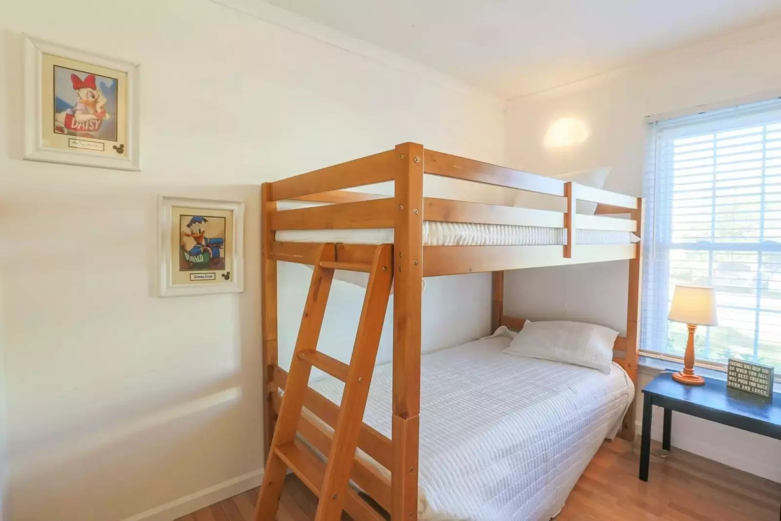 The bunk bedroom also has a nightstand with a reading lamp and two wall sconces.