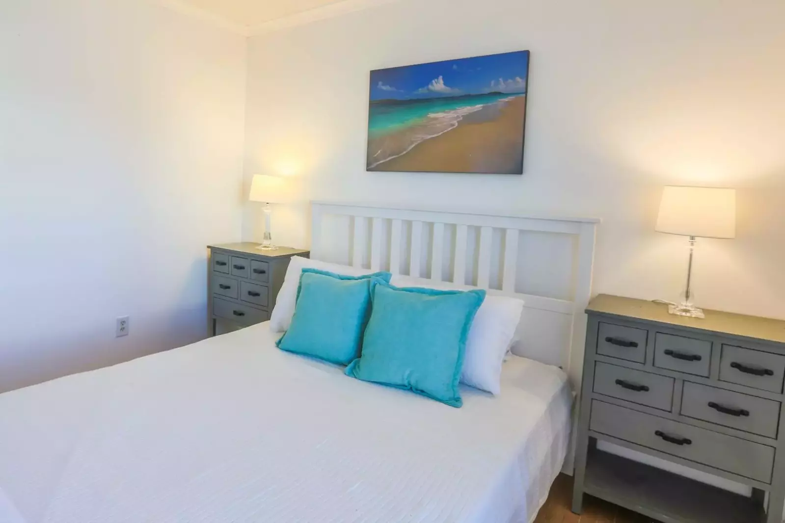 The bed is flanked by two nightstands with reading lamps.
