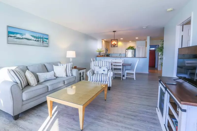 This oceanfront condo has an open layout between the living room, dining room & kitchen.