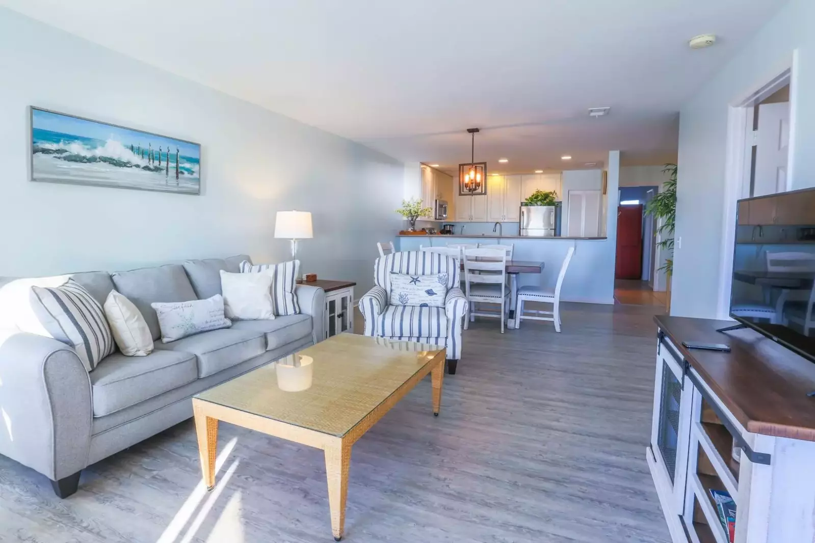 This oceanfront condo has an open layout between the living room, dining room & kitchen.