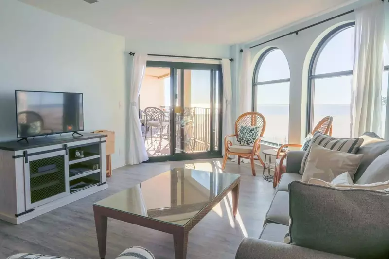 The living room features a large screen cable tv, ocean views and sliding door access to the private balcony.