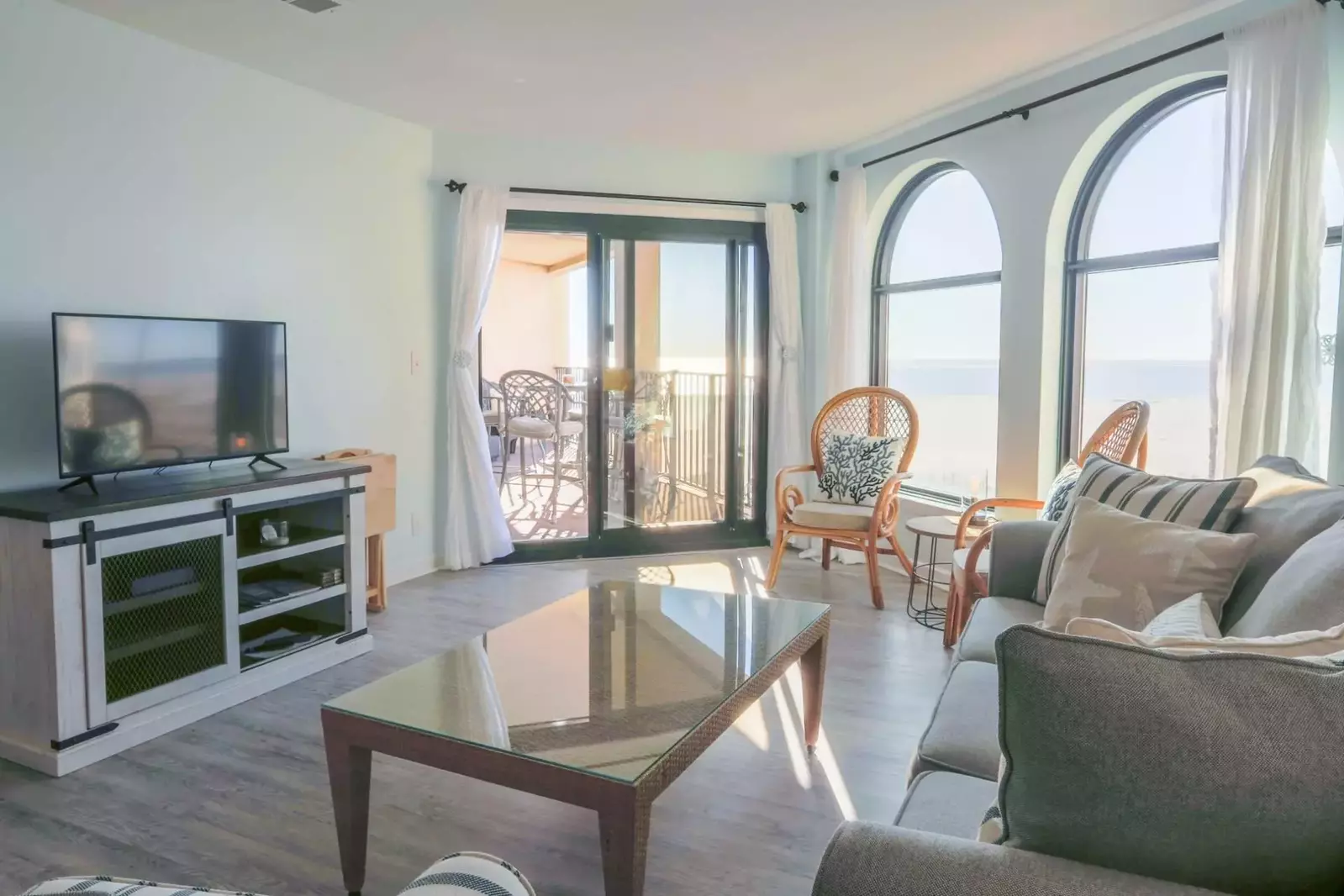 The living room features a large screen cable tv, ocean views and sliding door access to the private balcony.