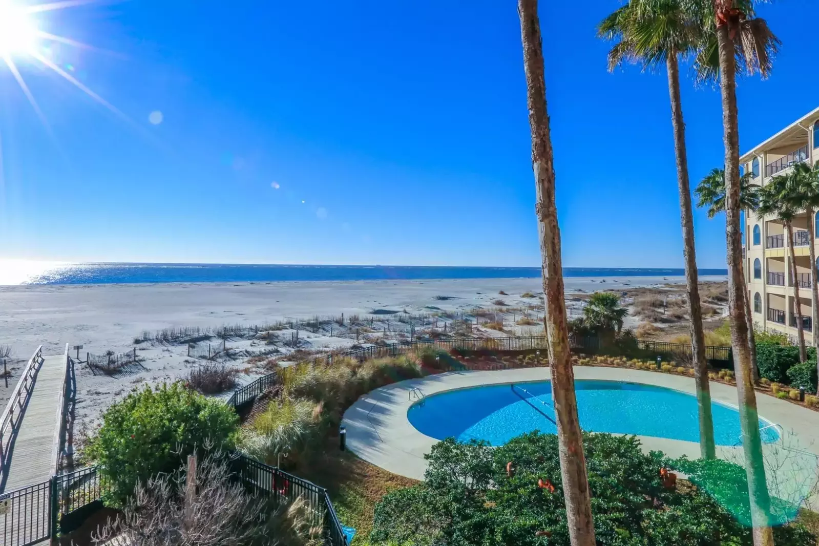 Beautiful grasses, palmetto trees and sand dunes surround the community pool and patio.