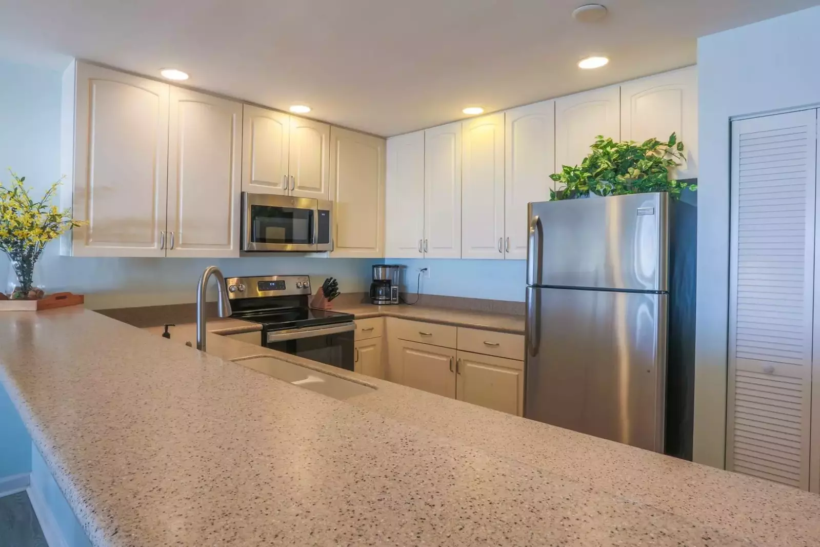 The kitchen features a range, microwave, coffee maker, dishwasher & more.