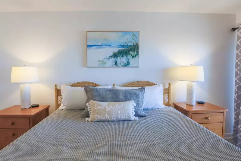 The master bedroom features a king bed, nightstands with reading lamp and ceiling fan.