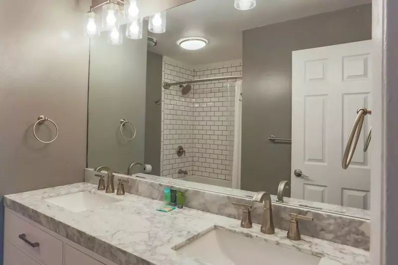 The renovated en suite bathroom has a double sink vanity.