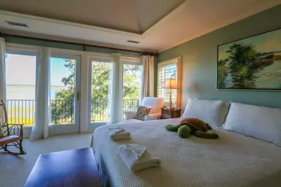 One full wall within the master bedroom features views of the tidal marsh below.