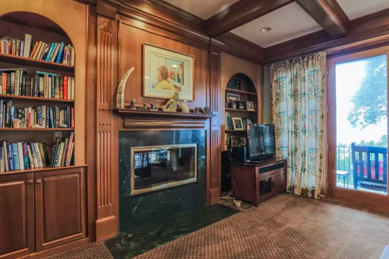 The den also has cherry-paneled walls and a wood-beamed ceiling.