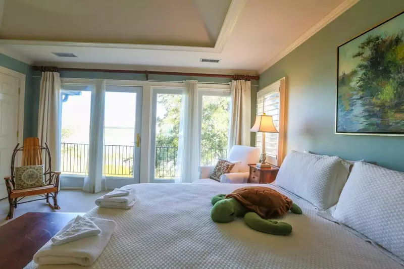 The master bedroom has a king bed, stunning views of the marsh and a private balcony.