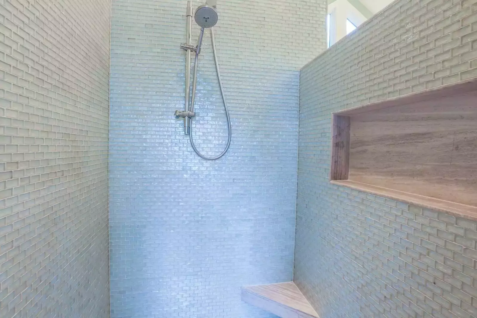 The beautiful glass tiles in the walk-in shower capture & reflect the light.