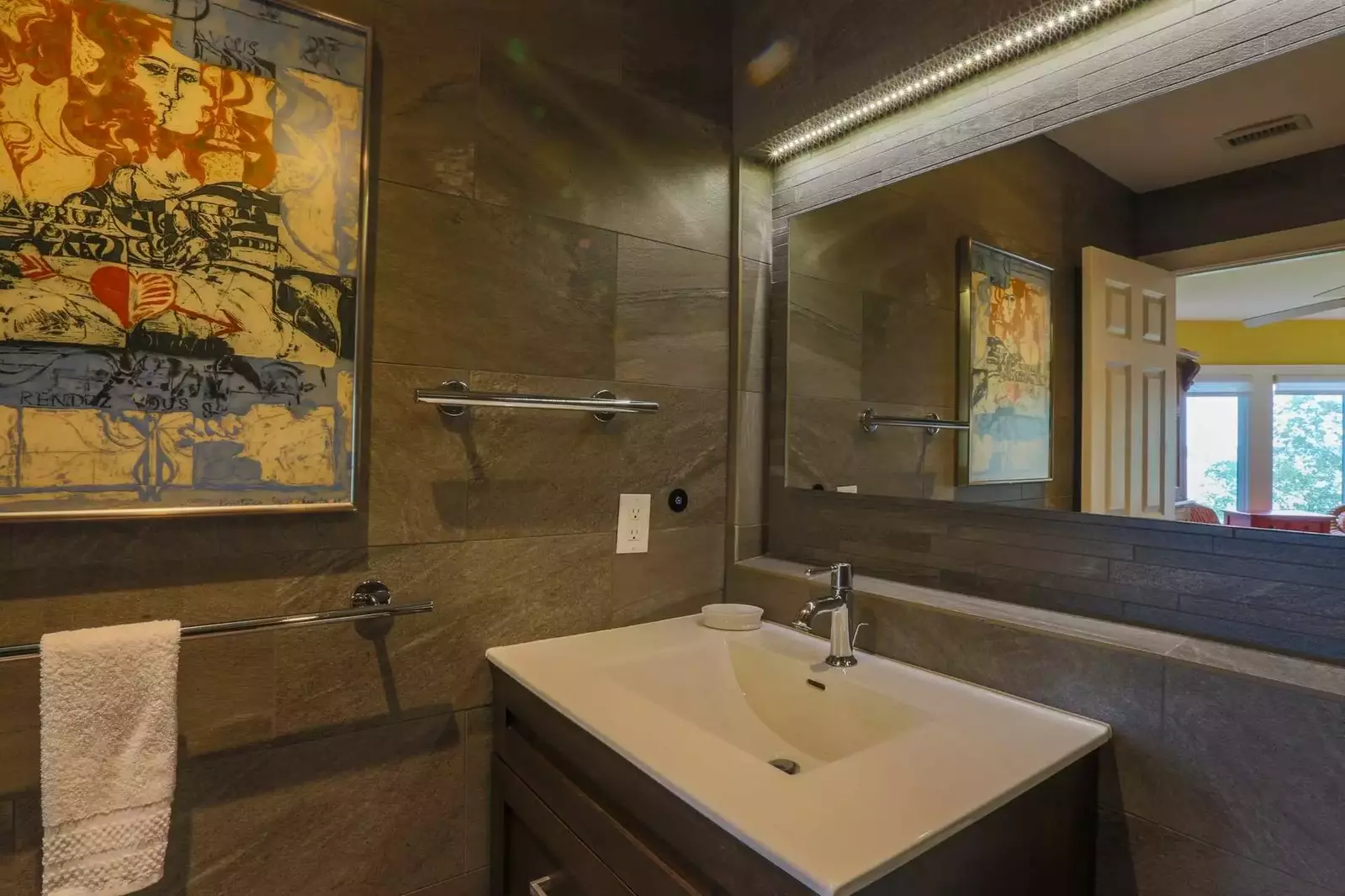 This gorgeous en suite bathroom features beautiful tilework and a spacious vanity.