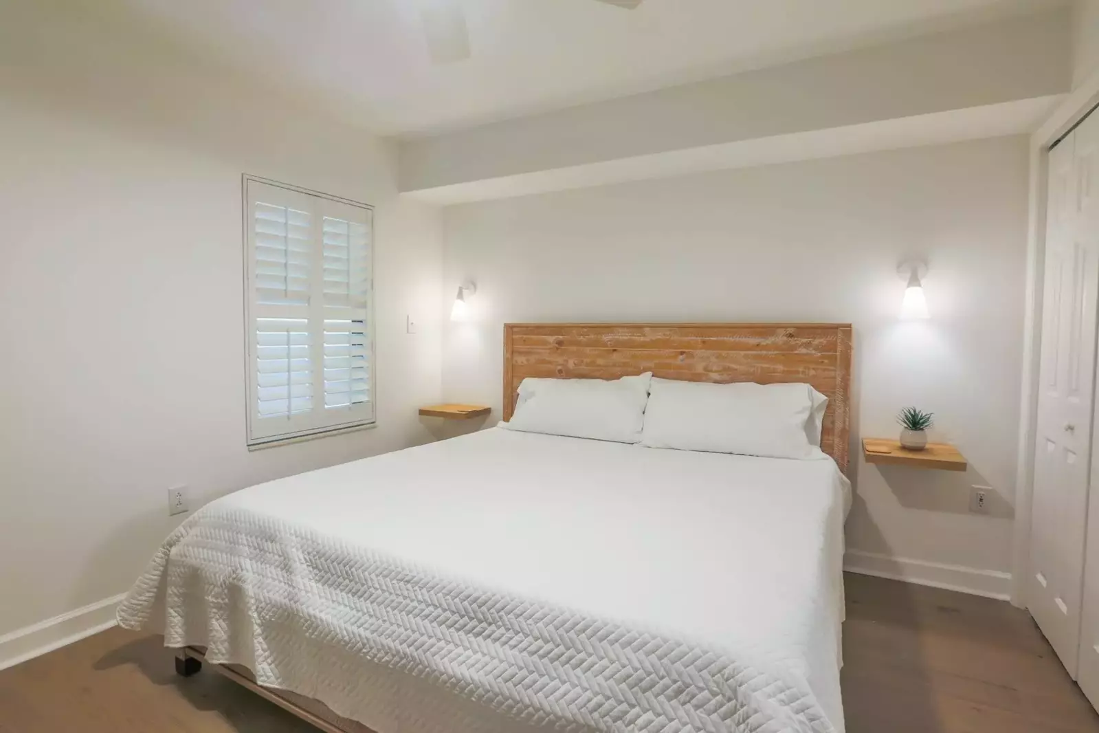 This is the condo's second master suite with a king bed, floating shelves and wall sconces.