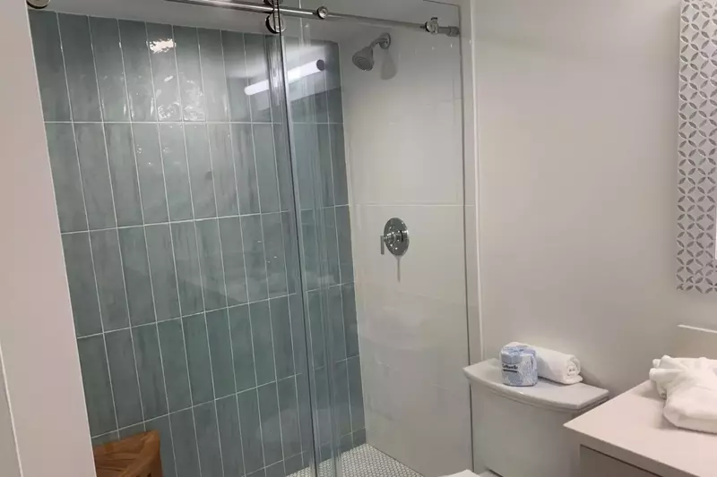 The en suite bathroom for the second master features a beautifully tiled walk-in shower.