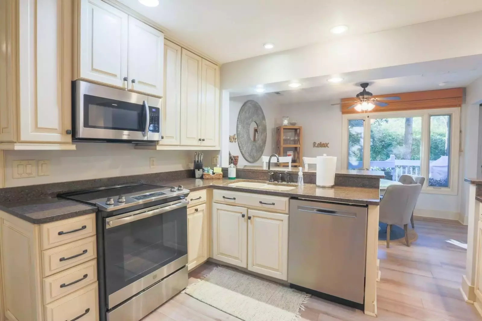 The renovated kitchen boasts stainless steel appliances, white cabinets and granite countertops.